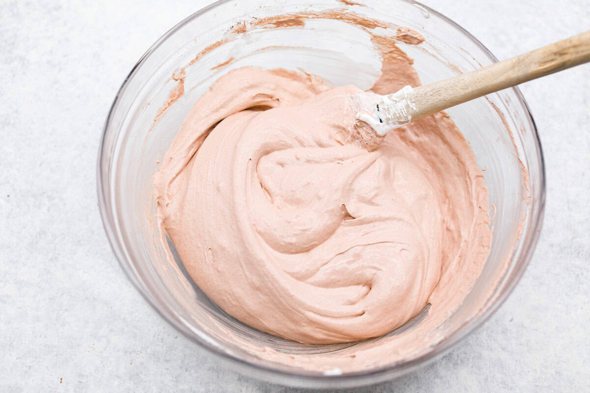 This hot cocoa dip recipe has only 3 ingredients and comes together in 5 minutes. It's chocolatey, fluffy, sweet, and creamy. It's perfect to take to holiday parties or cozy winter gatherings. Overhead shot of all the ingredients mixed together in a bowl.